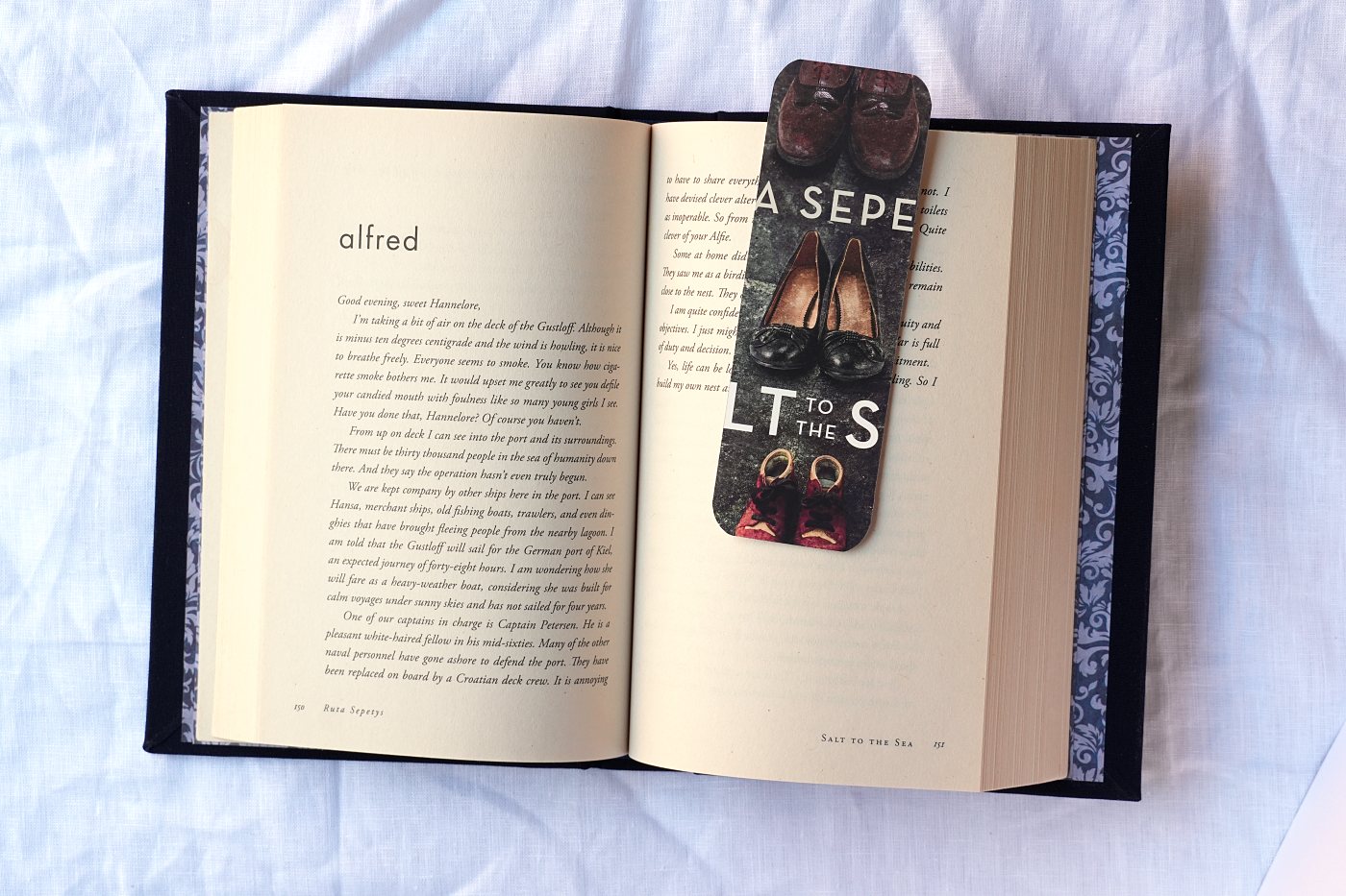 The book open in two hands, showing the original title page of the used paperback