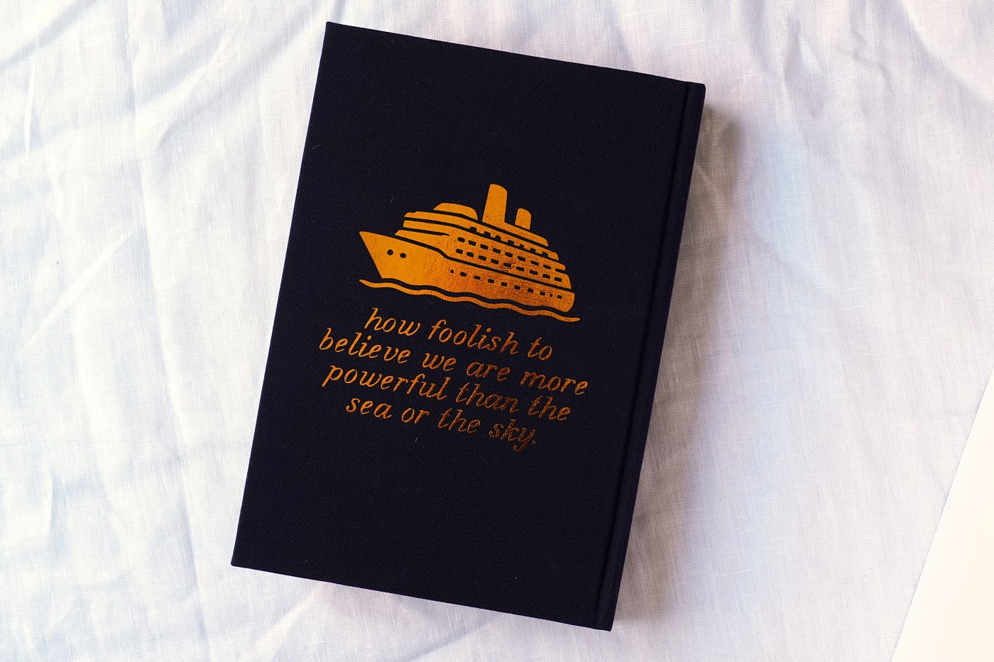 Back board with the ship and a line from the novel in gold foil