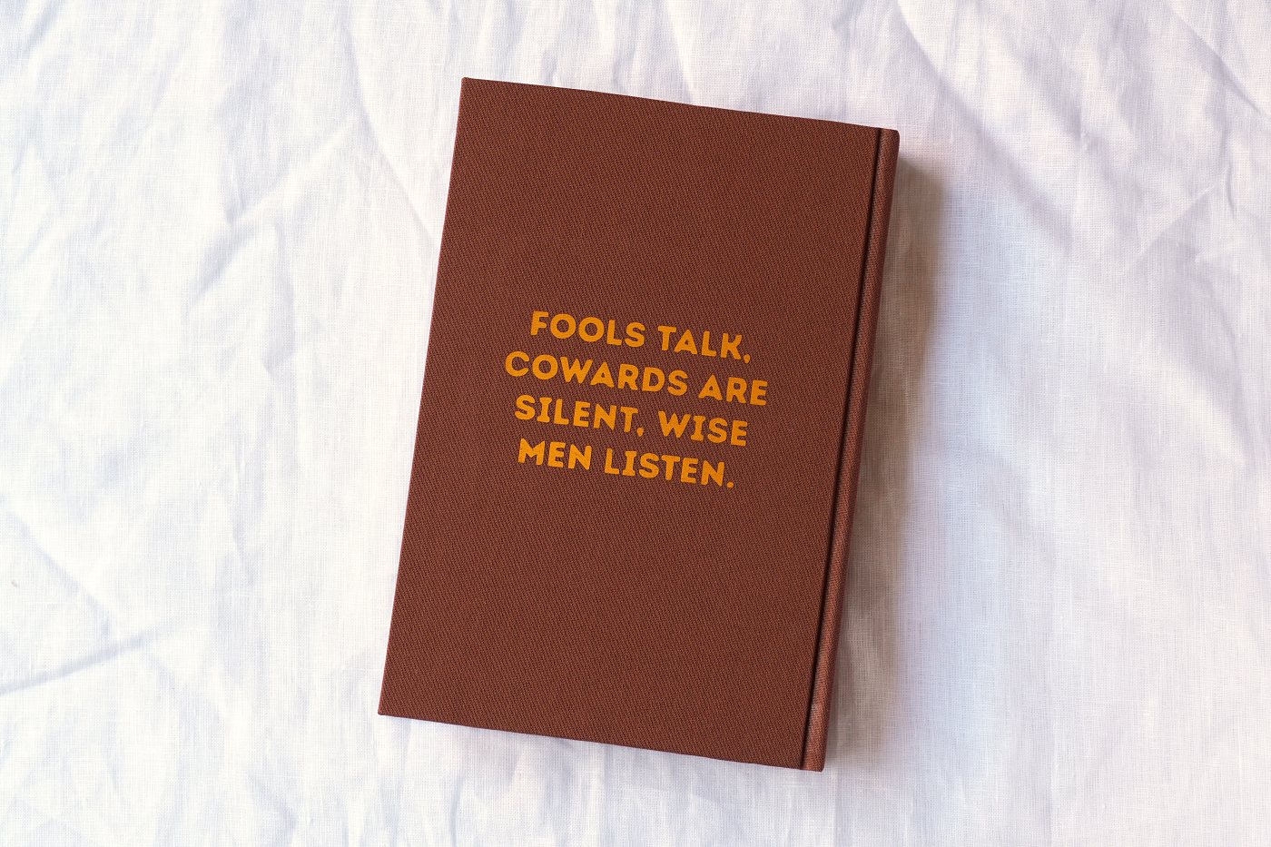 Back board with a line from the novel pressed in gold on oxblood cloth